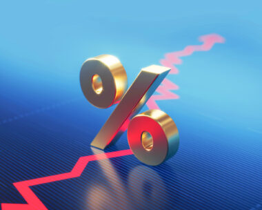 Percentage sign standing over a financial graph