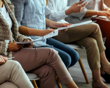business people sitting on chairs in waiting room