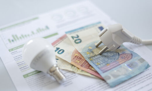 A white electric cap, a light bulb and euro banknotes on an electric bill