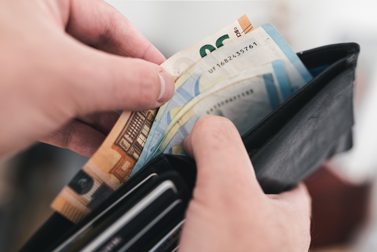 close-up view of hands taking money out of a wallet