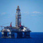 A large offshore oil rig in the middle of a vast expanse of ocean