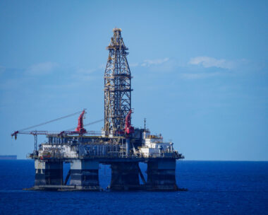 A large offshore oil rig in the middle of a vast expanse of ocean