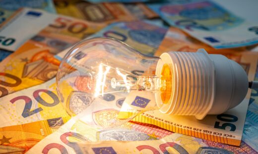 Light bulb lit, above euro banknotes