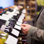 Unrecognizable young man in a wine shop choosing a wine