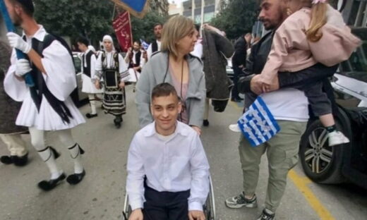 Μία μητέρα κρατάει το αμαξίδιο του γιου της