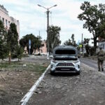 Ουκρανός στρατιώτης περιπολεί σε δρόμο δίπλα σε κτίρια που υπέστησαν ζημιές κατά τη διάρκεια πρόσφατων μαχών μεταξύ ουκρανικών και ρωσικών δυνάμεων στην ελεγχόμενη από την Ουκρανία πόλη Sudzha στην περιοχή Κουρσκ