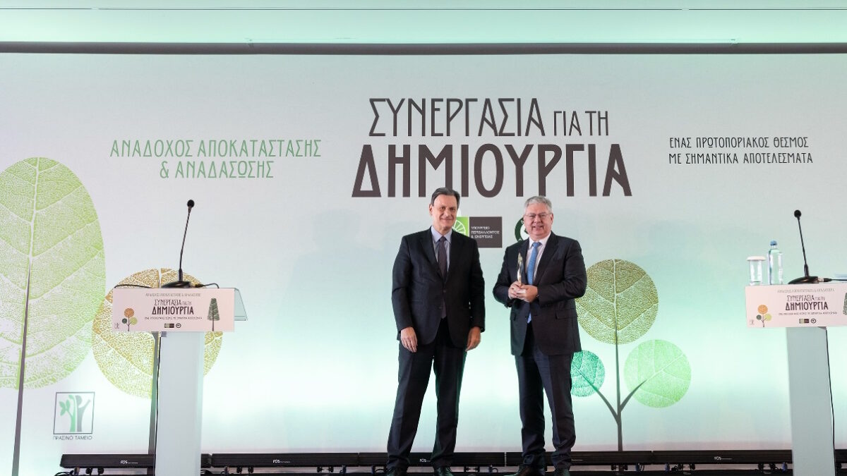 Ο Διευθύνων Σύμβουλος της HELLENiQ ENERGY Ανδρέας Σιάμισιης (δεξιά) δέχεται το τιμητικό βραβείο από τον τέως Υπουργό Περιβάλλοντος και Ενέργειας Θόδωρο Σκυλακάκη