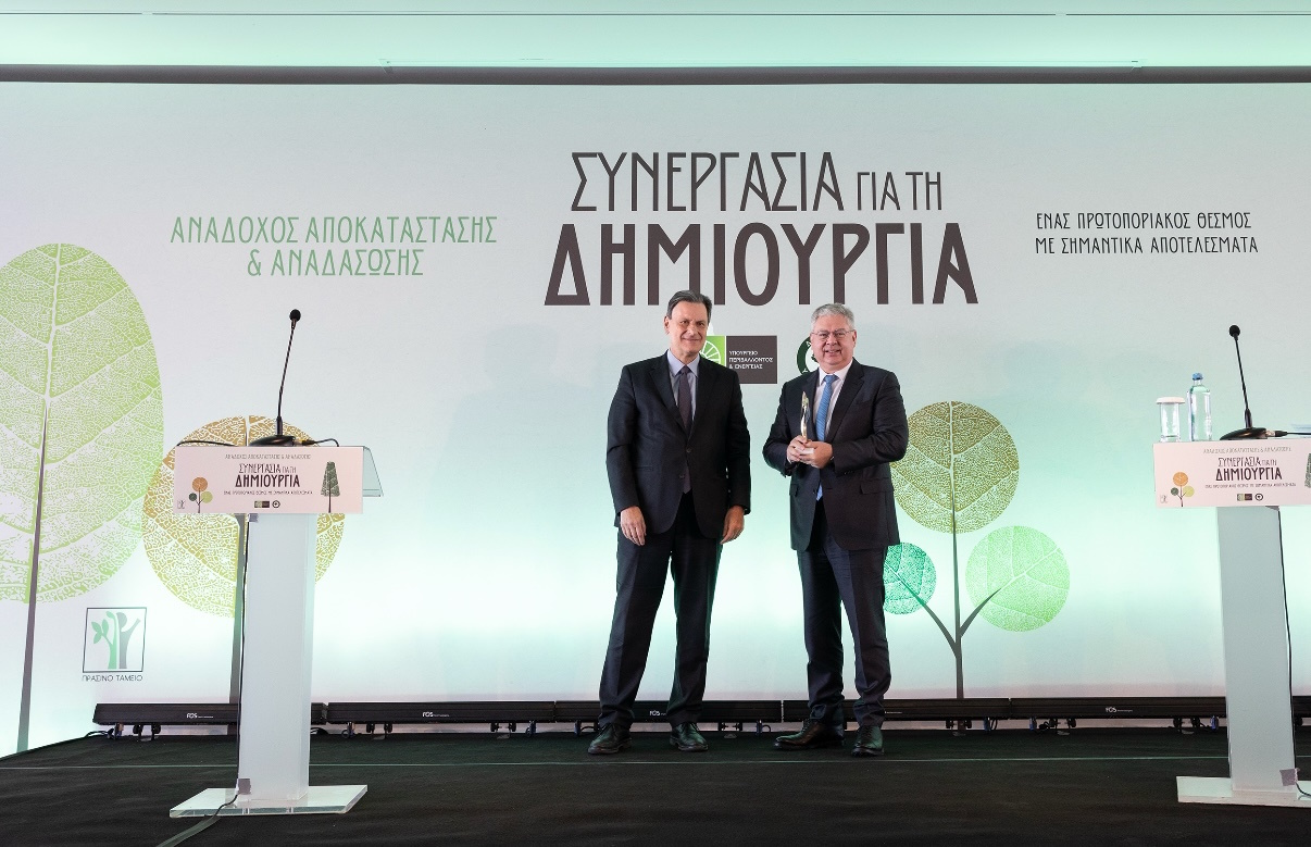 Ο Διευθύνων Σύμβουλος της HELLENiQ ENERGY Ανδρέας Σιάμισιης (δεξιά) δέχεται το τιμητικό βραβείο από τον τέως Υπουργό Περιβάλλοντος και Ενέργειας Θόδωρο Σκυλακάκη