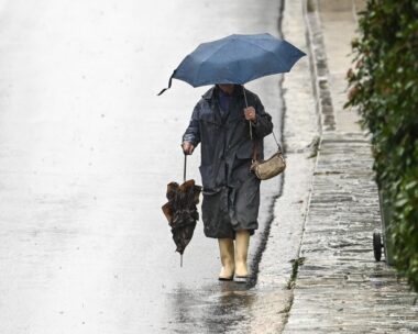 Γυναίκα με ομπρέλα λόγω έντονης βροχόπτωσης στην Αττική