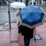 Άνθρωποι περπατούν στη βροχή