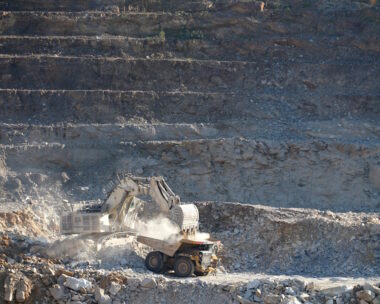 An excavator fills a dumper truck with ore at the Kibali gold mine