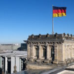German national flag flutters on top of the Reichstag building