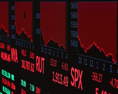 A screen shows trading indexes at the New York Stock Exchange