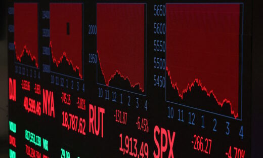 A screen shows trading indexes at the New York Stock Exchange