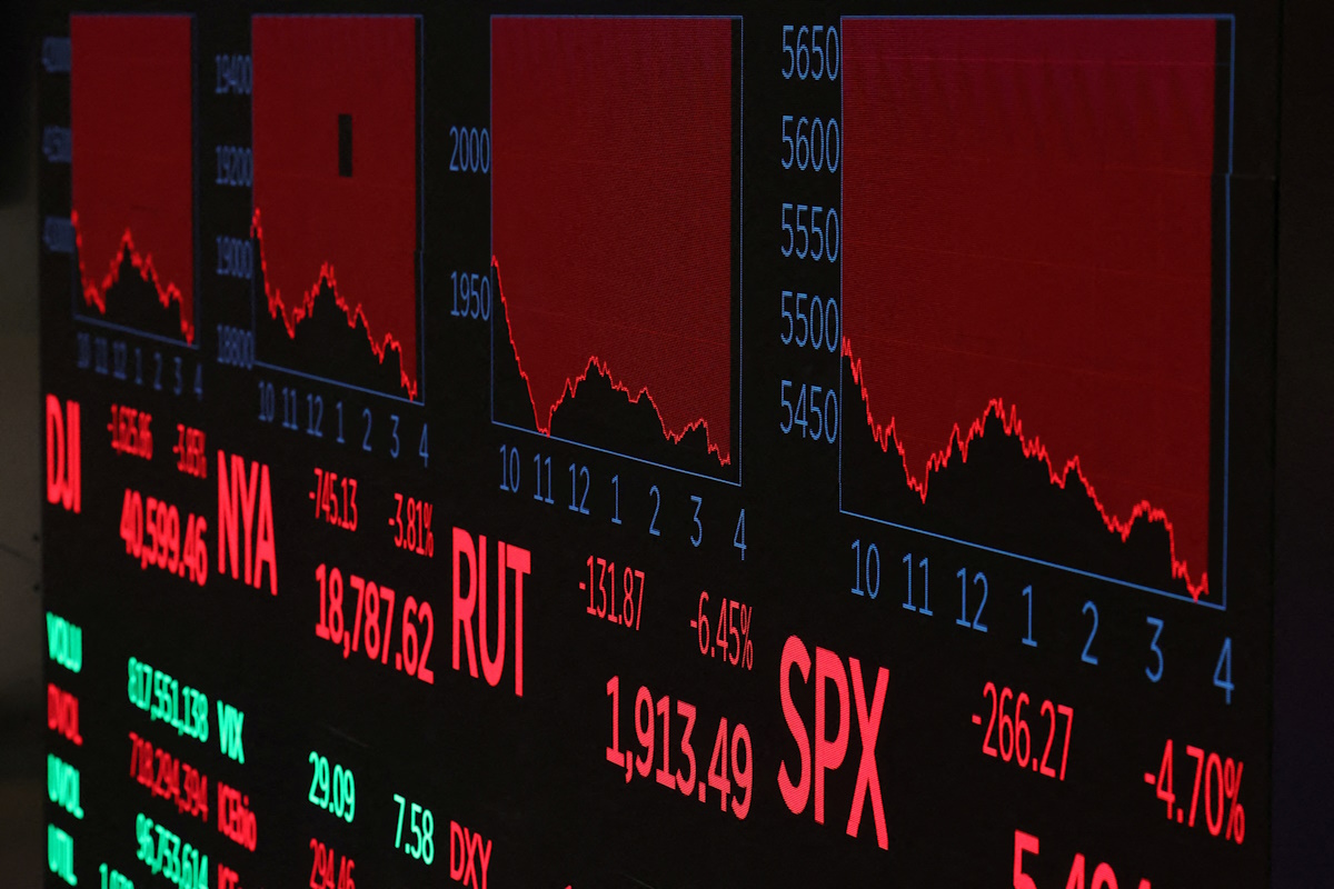 A screen shows trading indexes at the New York Stock Exchange