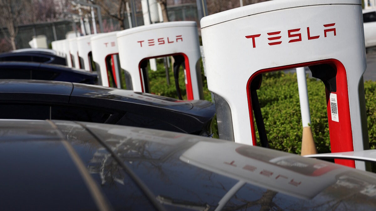 Tesla cars charge at a Supercharger charging station