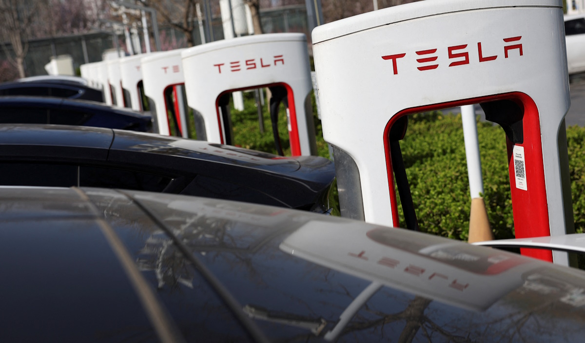 Tesla cars charge at a Supercharger charging station