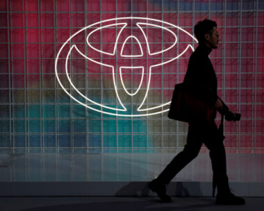 A man walks past a Toyota logo