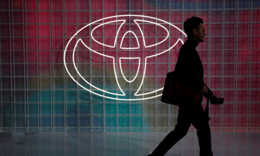 A man walks past a Toyota logo