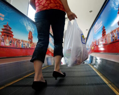 A shopper carries groceries she bought in a plastic bag in Beijing