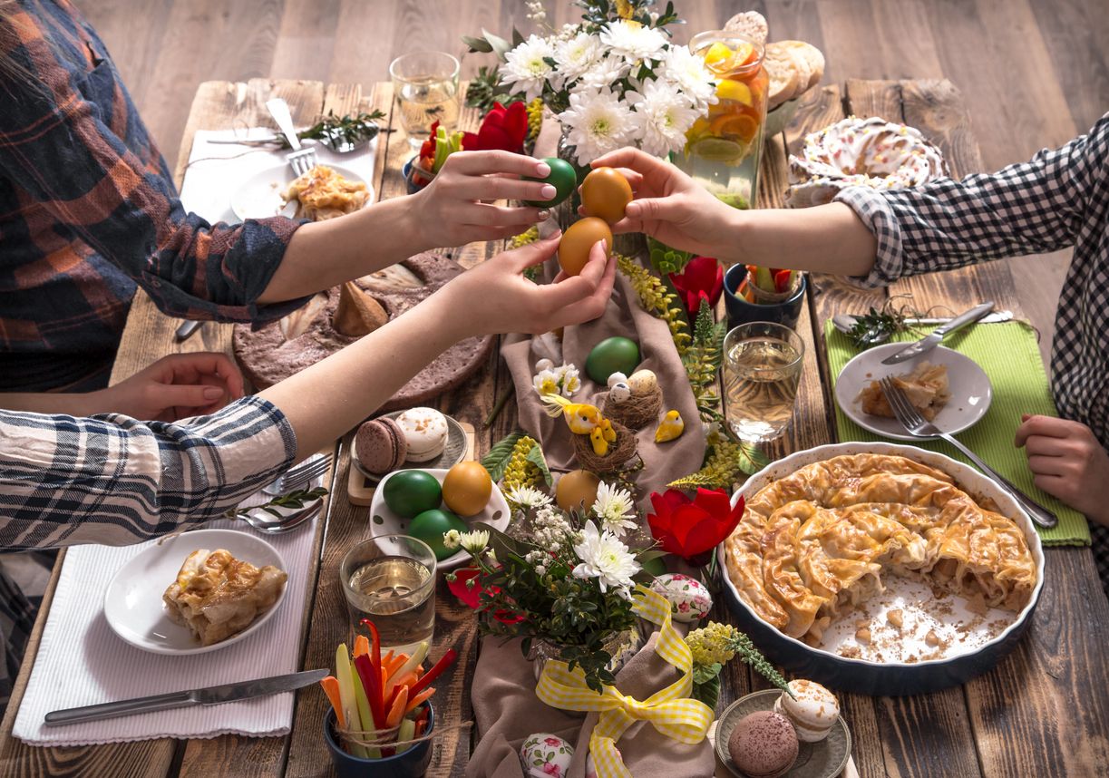Home Holiday friends or family at the festive Easter table with Easter colored eggs. The concept of the celebration