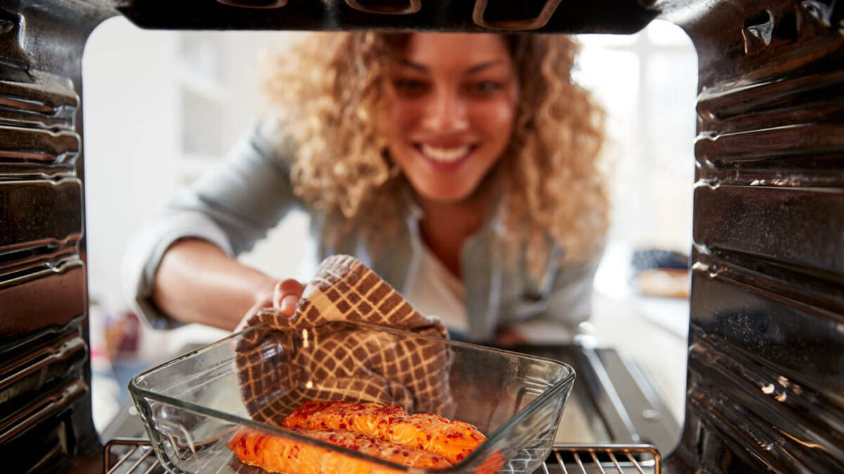 View Looking Out From Inside Oven As Woman Cooks Oven Baked Salmon