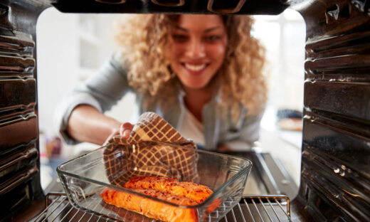 View Looking Out From Inside Oven As Woman Cooks Oven Baked Salmon