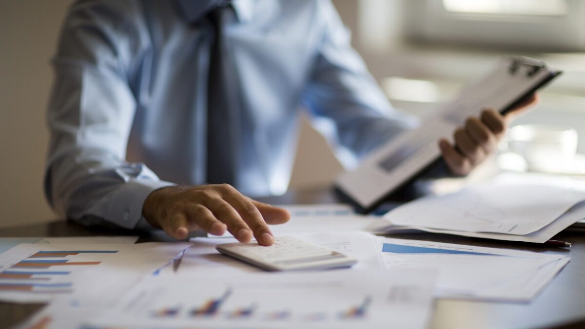 Business accounting concept, Business man using calculator with computer laptop, budget and loan paper in office