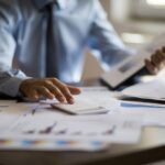 Business accounting concept, Business man using calculator with computer laptop, budget and loan paper in office
