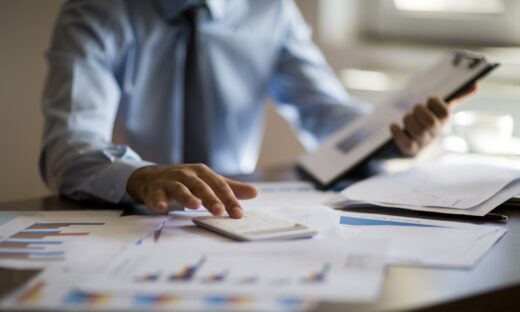 Business accounting concept, Business man using calculator with computer laptop, budget and loan paper in office