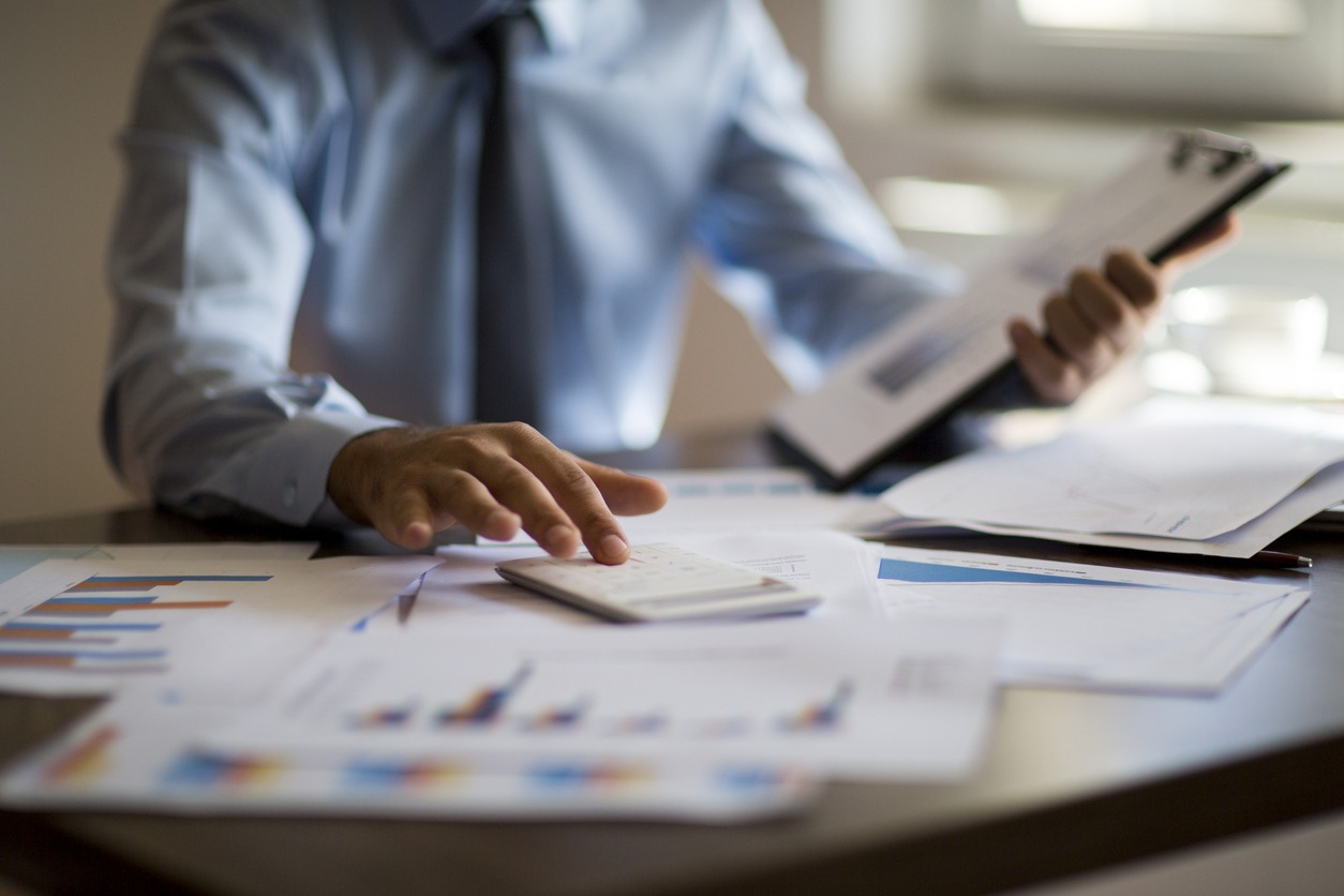 Business accounting concept, Business man using calculator with computer laptop, budget and loan paper in office