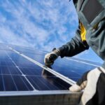 Close up of man technician in work gloves installing stand-alone photovoltaic solar panel system