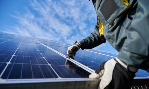 Close up of man technician in work gloves installing stand-alone photovoltaic solar panel system