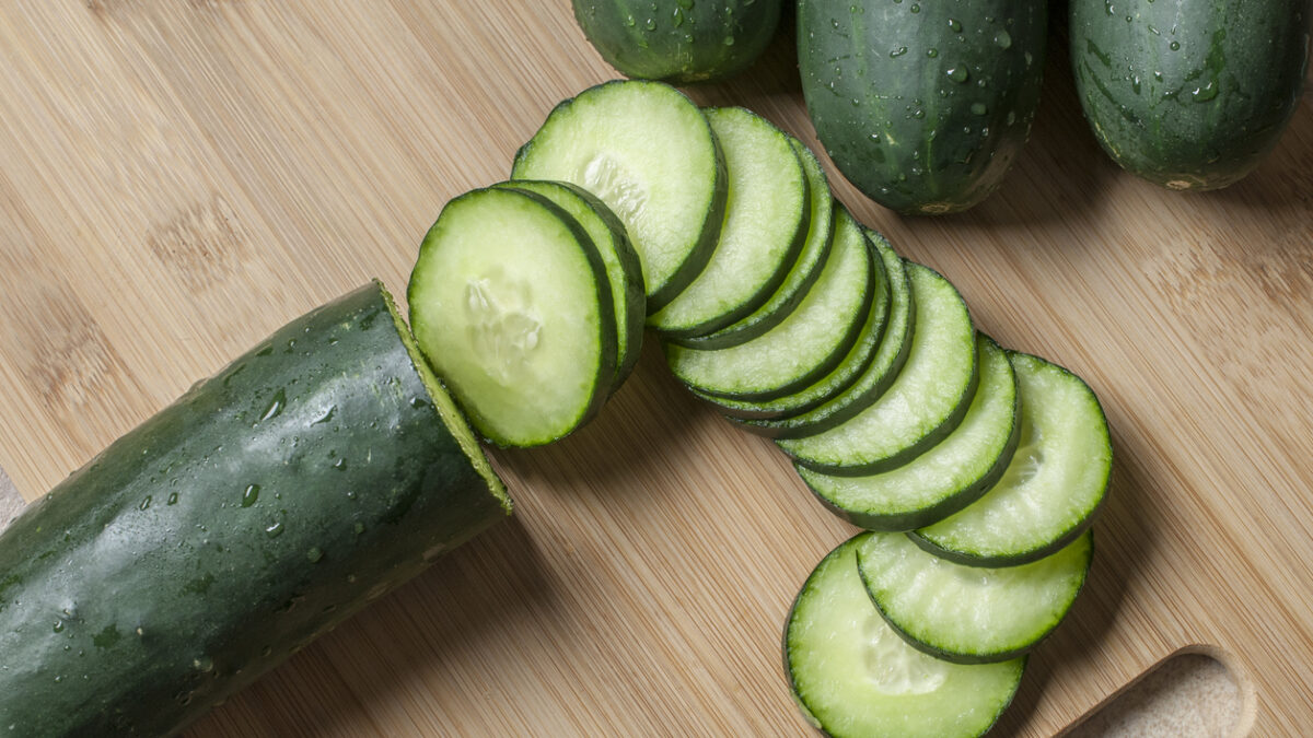 Fresh cucumber slices on a wooden cutting board