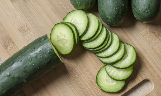 Fresh cucumber slices on a wooden cutting board