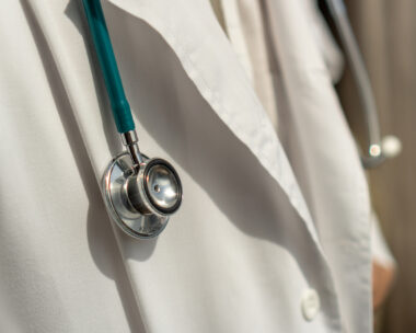 Medical doctor or physician in white gown uniform with stethoscope in hospital or clinic fighting with COVID-19 with laboratory background banner