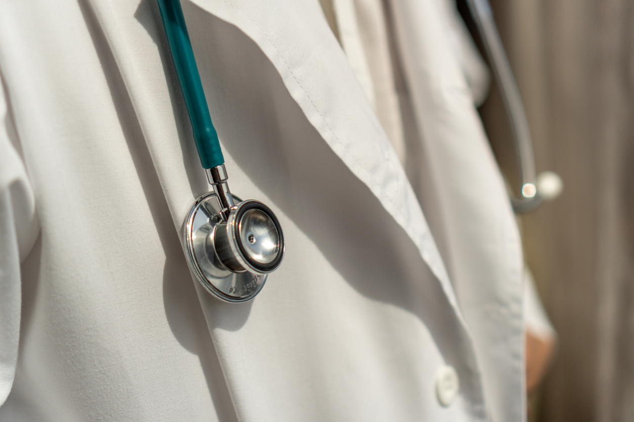 Medical doctor or physician in white gown uniform with stethoscope in hospital or clinic fighting with COVID-19 with laboratory background banner
