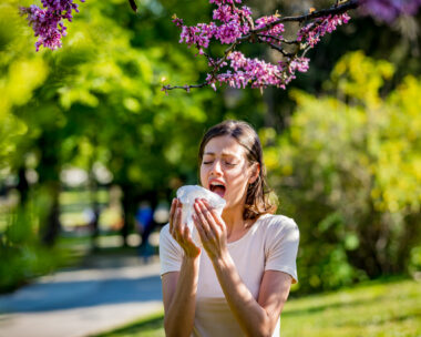 Woman has sneezing. Young woman is having flu and she is sneezing. Sickness, seasonal virus problem concept. Woman being sick having flu sneezing.