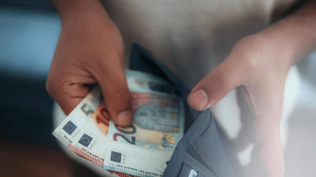 Young man holding in hands wallet with euro money