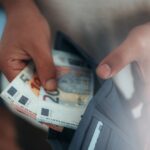 Young man holding in hands wallet with euro money