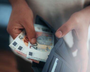 Young man holding in hands wallet with euro money