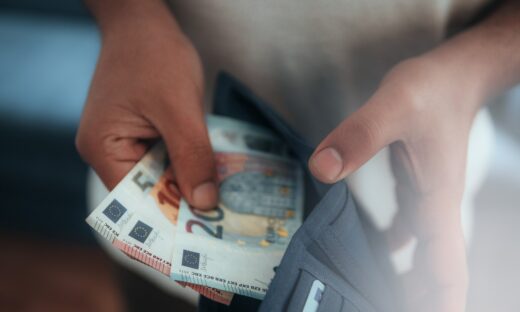Young man holding in hands wallet with euro money