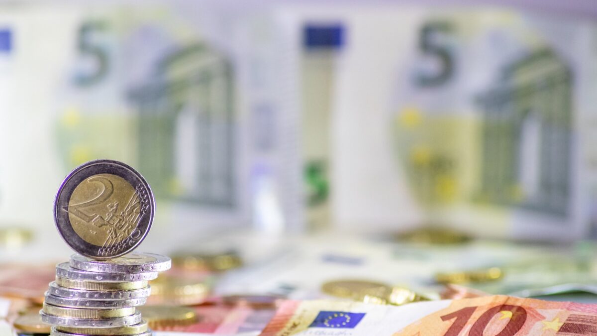 Stack of european coins and bank notes in the background show international finance with euro and europe, european trade and financial trade as well as saving, financial success and credit management