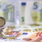 Stack of european coins and bank notes in the background show international finance with euro and europe, european trade and financial trade as well as saving, financial success and credit management