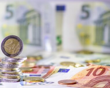 Stack of european coins and bank notes in the background show international finance with euro and europe, european trade and financial trade as well as saving, financial success and credit management