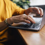 Close up shot of an woman typing on her laptop