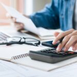 Investors are calculating profits and costs with calculators, growth and investment chart analysis, business planning and strategies to maximize sales profits