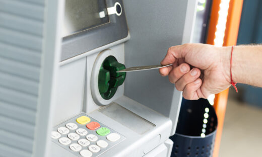Human hand inserting a credit card into an ATM