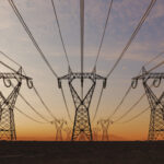 The silhouette of the high voltage power lines during sunset