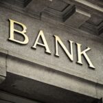 An old fashioned 'Bank' sign on a building exterior.